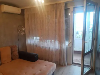 a living room with a couch and a large window at Apartment near Bulgaria Boulevard in Sofia