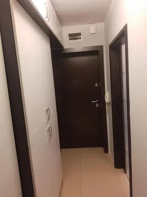 a hallway with a black door and a tile floor at Apartment near Bulgaria Boulevard in Sofia