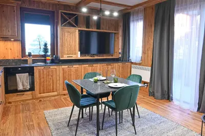 a kitchen with a table with chairs and a television at Cozy 1-Bedroom Apartment in St Ivan Ski Resort by Flat Mаnаger in Blagoevgrad
