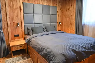 a bedroom with a large bed with a large headboard at Cozy 1-Bedroom Apartment in St Ivan Ski Resort by Flat Mаnаger in Blagoevgrad