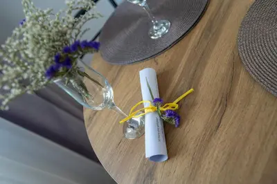 a table with a candle and a vase with flowers at Apartment By The River 5 in Plovdiv