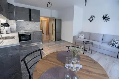 a kitchen and living room with a table and a couch at Apartment By The River 5 in Plovdiv