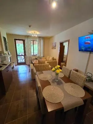 a living room with a table with chairs and a couch at Lucky SP apartments -Pamporovo in Bŭnzareto