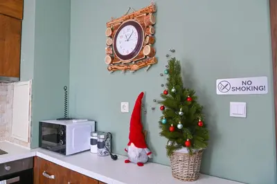 a christmas tree on a kitchen counter with a clock at Comfortable 2-Bedroom Apartment Near the Ski Lift by Flat Mаnаger in Bansko