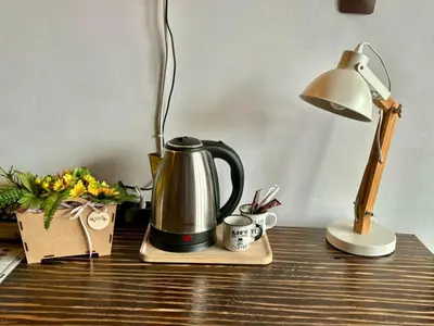 a coffee pot and a lamp on a desk at Семеен хотел-ресторант Маламовата къща in Gotse Delchev