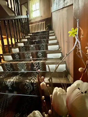 a group of stairs in a building with a plant at Семеен хотел-ресторант Маламовата къща in Gotse Delchev