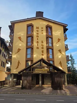 a building with a sign on the side of it at TMF Mountain Lodge Cozy Studio apartment in Pamporovo