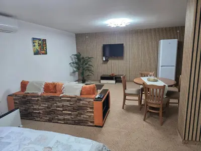 a living room with a couch and a table with a dining room at TMF Mountain Lodge Cozy Studio apartment in Pamporovo