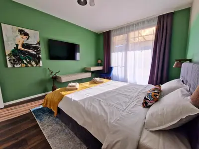 a bedroom with green walls and a large bed at By The Pool Apartments #7 in Velingrad