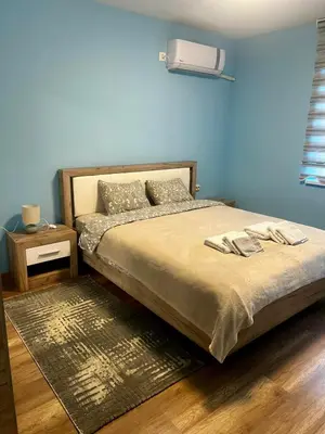 a bedroom with a bed and a blue wall at Raya - Apartmant in Plovdiv, with private parking in Plovdiv