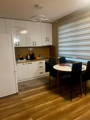 a kitchen with a table and chairs in a room at Raya - Apartmant in Plovdiv, with private parking in Plovdiv