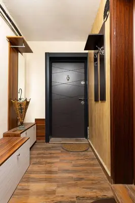 a hallway with a black door and a wooden floor at Convenient Studio with great view over Plovdiv in Plovdiv