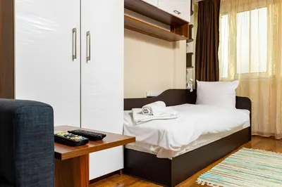 a bedroom with a bed and a table and a chair at Convenient Studio with great view over Plovdiv in Plovdiv