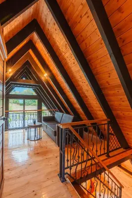 an attic room with a couch and a wooden ceiling at Camping Between the Mountains Bansko in Bansko
