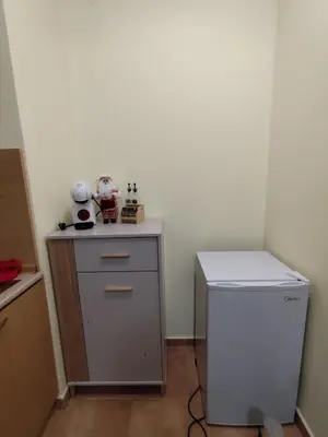 a small room with a small refrigerator and a table at Замъка in Pamporovo