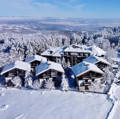 a resort in the snow with snow covered roofs at Dreaming apartment with tree Mountain view in Borovets