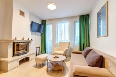 a living room with a couch and a fireplace at Two-bedroom Apartment in the Heart of the Rhodopes in Pamporovo