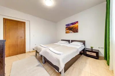 a bedroom with two beds and a wooden door at Two-bedroom Apartment in the Heart of the Rhodopes in Pamporovo