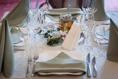 a table with glasses and plates and silverware on it at Hotel Chiirite in Plovdiv