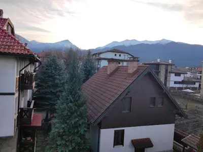 a house with a red roof and some trees at Fantasy in Bansko