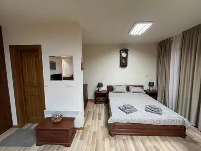 a bedroom with a bed and a clock on the wall at PIRIN GOLF DELUXE PRIVATE STUDIO GABBY ground floor in Bansko