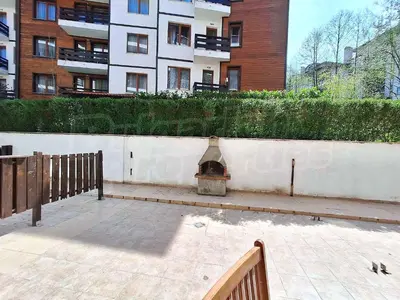 a courtyard with a brick fireplace next to a building at Studio 4, 4min walk to slope at Predela2 Bansko in Bansko