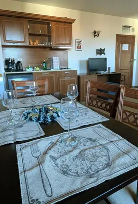 a dining room table with wine glasses on it at Mountain view apartment at Emerald Hotel in Bansko