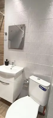 a bathroom with a white toilet and a sink at VB Residence Vitosha View Apartment in Sofia