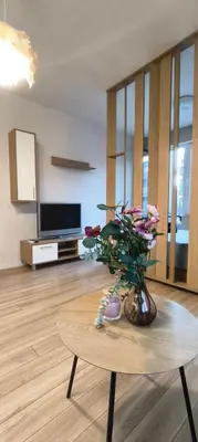 a living room with a table with a vase of flowers at VB Residence Vitosha View Apartment in Sofia