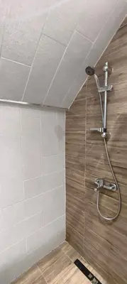 a shower in a bathroom with a tile wall at VB Residence Vitosha View Apartment in Sofia