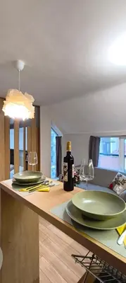 two green plates and wine glasses on a kitchen counter at VB Residence Vitosha View Apartment in Sofia