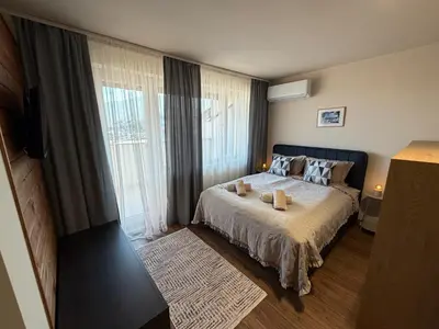 a bedroom with a bed and a large window at Bansko Royal Towers Ski Lift View in Bansko