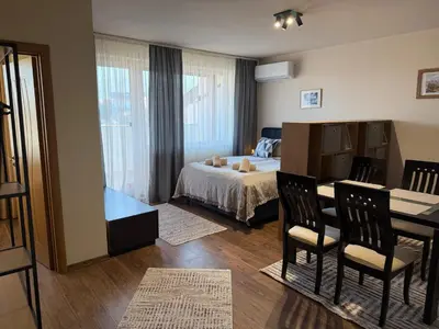 a bedroom with a bed and a table and chairs at Bansko Royal Towers Ski Lift View in Bansko
