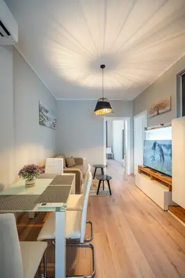 a living room with a dining table and a tv at The Urban Pulse Stylish Flat in Sofia