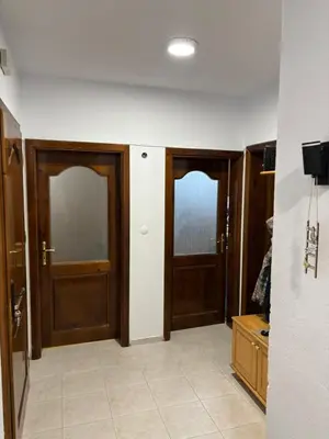 a hallway with two wooden doors in a room at Kiryanov's apartment in Sandanski