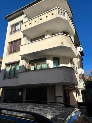a tall building with a car parked in front of it at Kiryanov's apartment in Sandanski