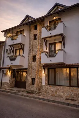 a large white building with windows on a street at Хотел Ривърсайд Анекс in Bansko
