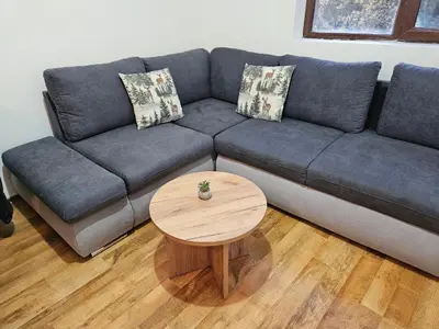 a living room with a blue couch and a wooden table at Apartment Kapina in Pamporovo