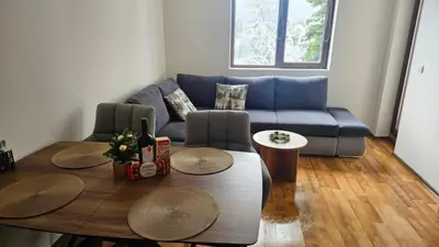 a living room with a blue couch and a table at Apartment Kapina in Pamporovo
