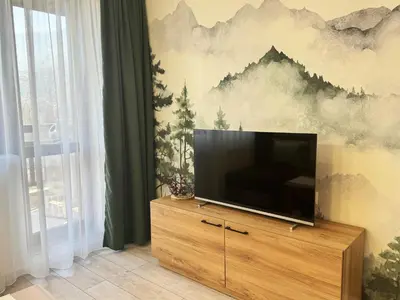 a flat screen tv sitting on top of a wooden dresser at EMIS Alpine Retreat - Modern & Cozy & Bright in Bansko