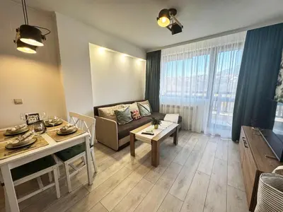 a living room with a couch and a table at EMIS Alpine Retreat - Modern & Cozy & Bright in Bansko