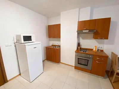 a small kitchen with a refrigerator and a microwave at Private Studio 500m from Gondola in Bansko