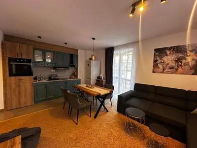 a kitchen and a living room with a couch and a table at Apartment 35 Mountain Lodge Pamporovo in Pamporovo