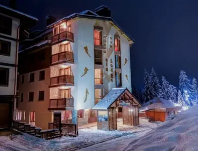 a large building in the snow at night at Apartment 35 Mountain Lodge Pamporovo in Pamporovo
