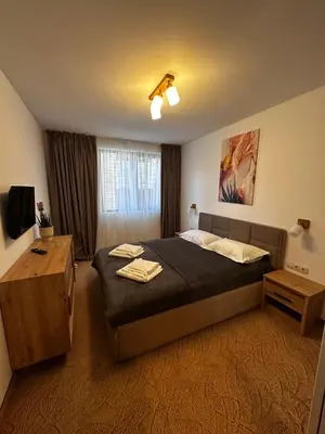 a hotel room with a bed and a television at Apartment 35 Mountain Lodge Pamporovo in Pamporovo