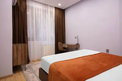 a bedroom with a bed and a desk and a window at Central 2BR Near Vitosha - Calm, Spacious Stay in Sofia
