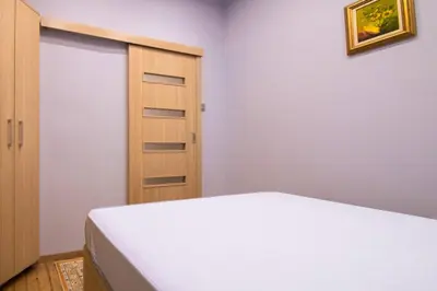 a bedroom with a bed and a wooden door at Central 2BR Near Vitosha - Calm, Spacious Stay in Sofia