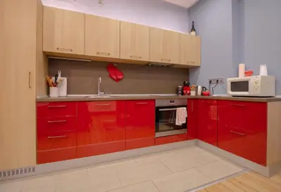 a kitchen with red cabinets and a microwave at Central 2BR Near Vitosha - Calm, Spacious Stay in Sofia