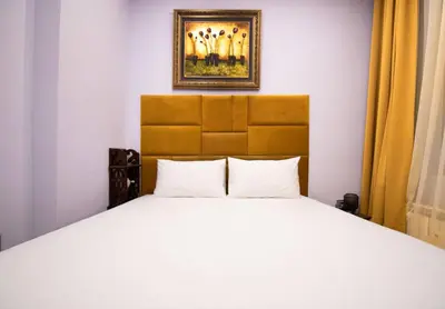 a bed in a bedroom with a picture on the wall at Central 2BR Near Vitosha - Calm, Spacious Stay in Sofia