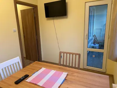 a dining room table with a television on the wall at Flat in Darvenitsa near Church St George the Victorious in Sofia